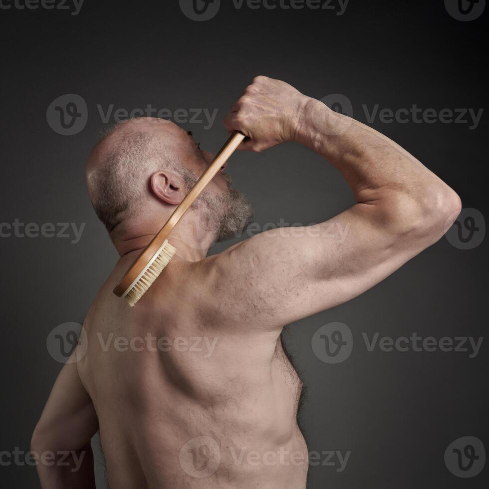 senior man is practicing dry brushing photo