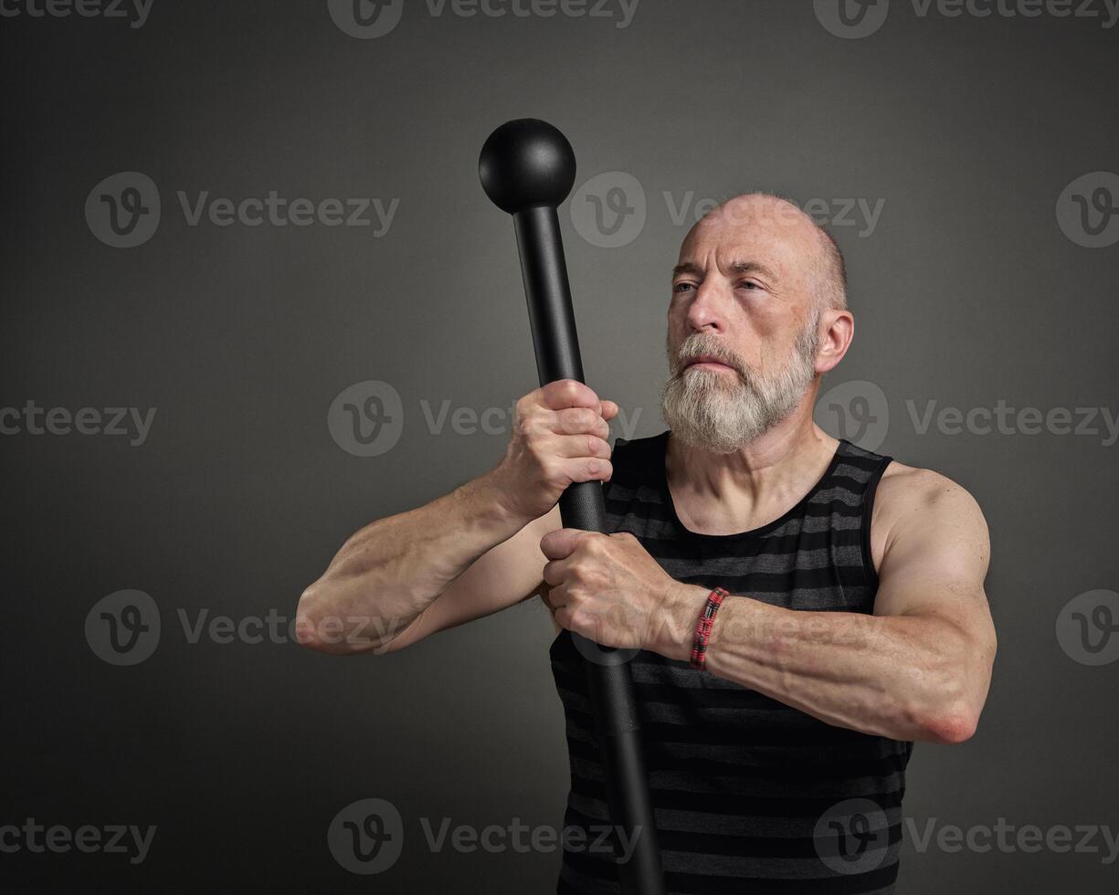 senior man is exercising with steel mace photo