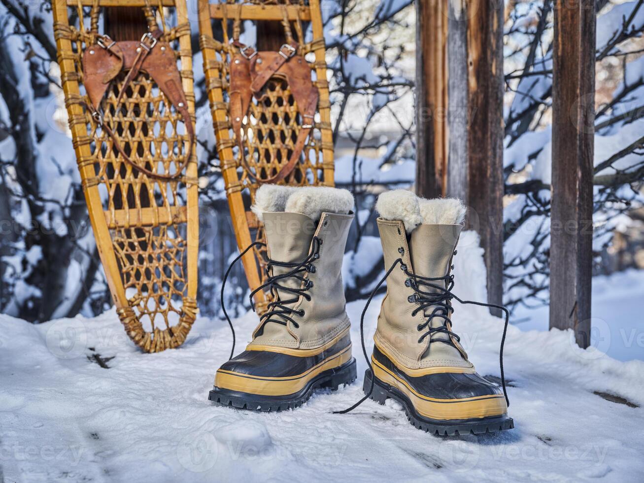 Heavy snow boots and classic wooden snowshoes photo