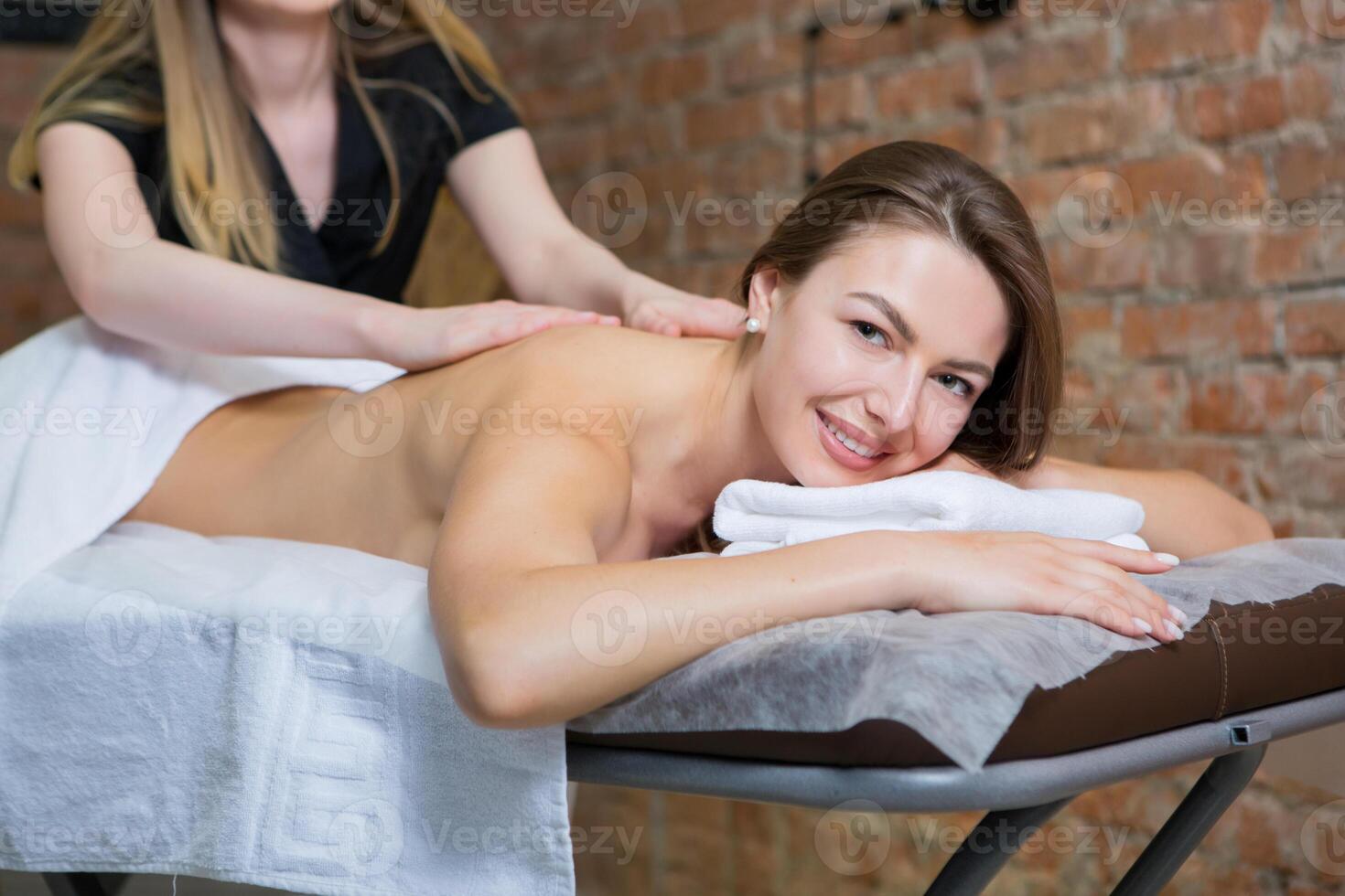 Young woman getting a back massage in a spa salon. Beauty treatment concept. photo