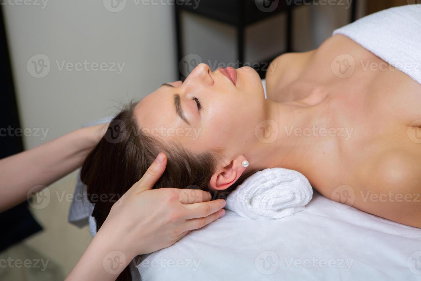 Young woman getting a back massage in a spa salon. Beauty treatment concept. photo