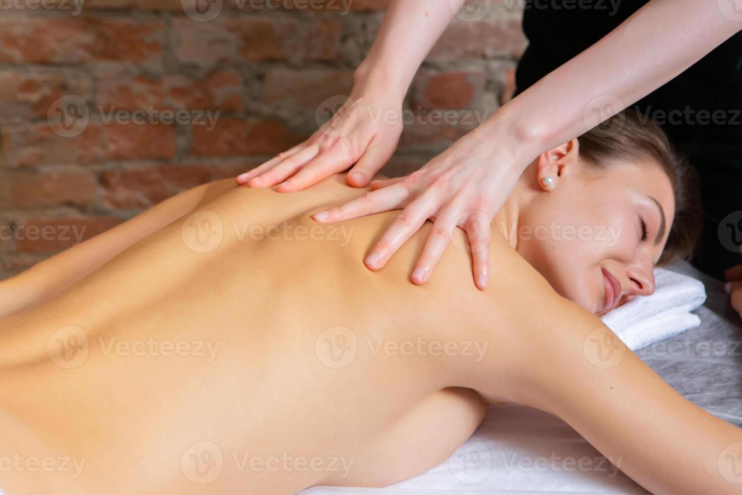 Young woman getting a back massage in a spa salon. Beauty treatment concept. photo