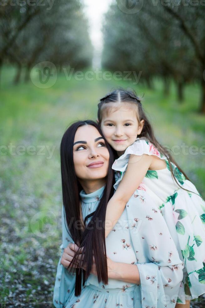 A happy family. Mother and daughter rest in the park in dresses photo