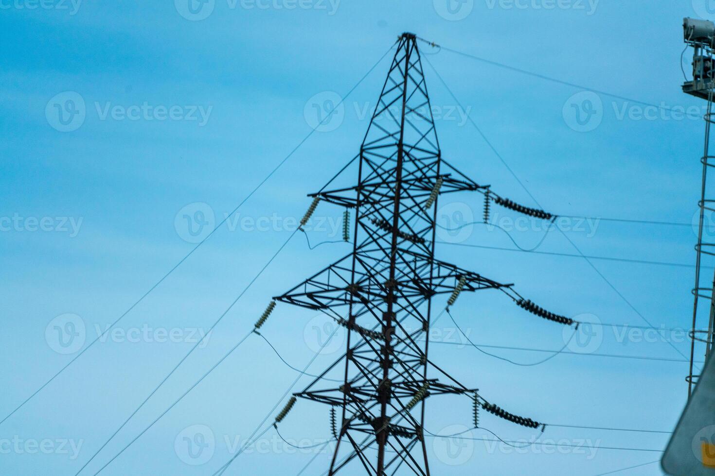 High voltage towers with sky background. Power line support with wires for electricity transmission. High voltage grid tower with wire cable at distribution station. Energy industry, energy saving photo