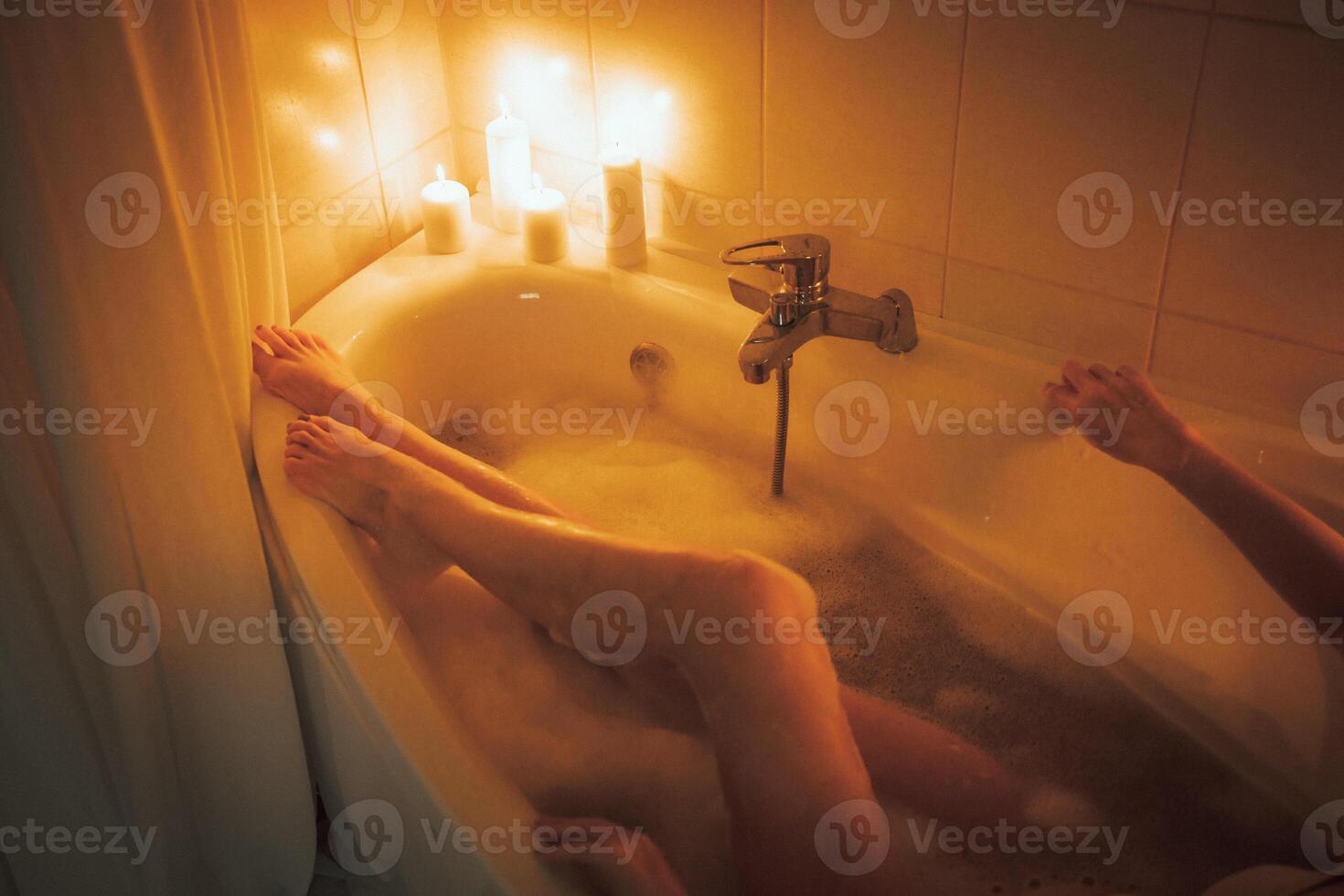 Women's feet in bath foam. View from above. Enjoy and relax in a spa hotel photo