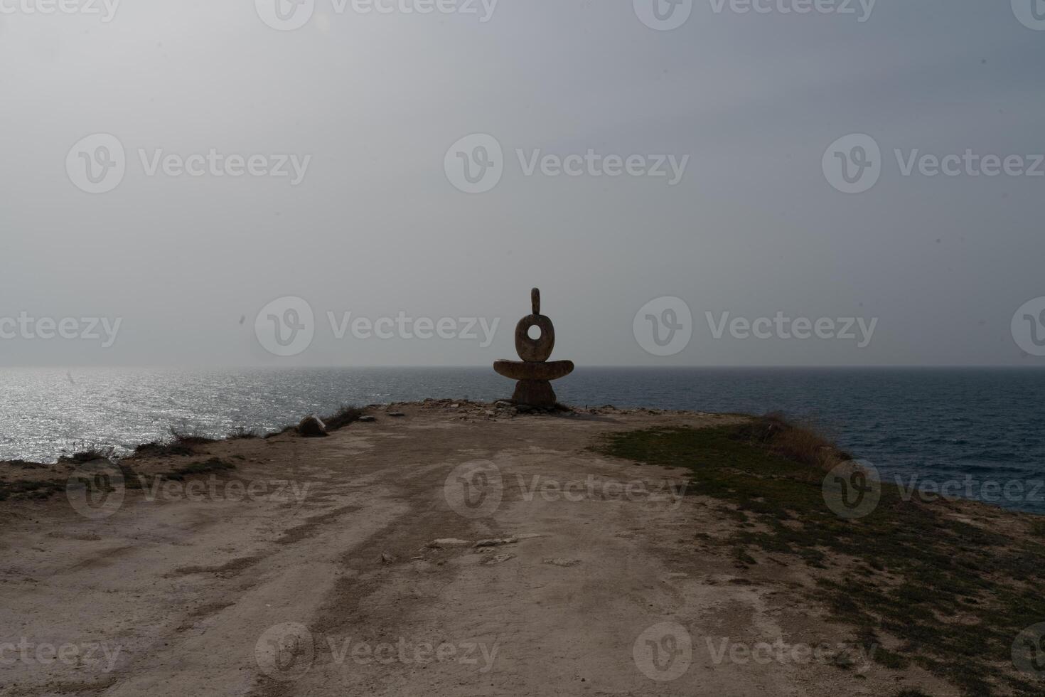 Sculpture symbol made of large pebbles against the blue sky photo