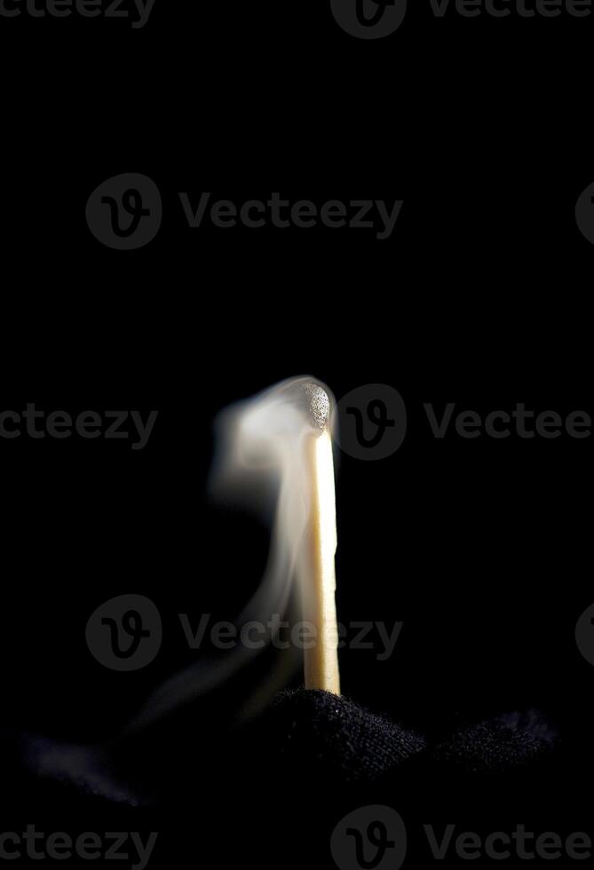 Wooden match burning on a black background photo