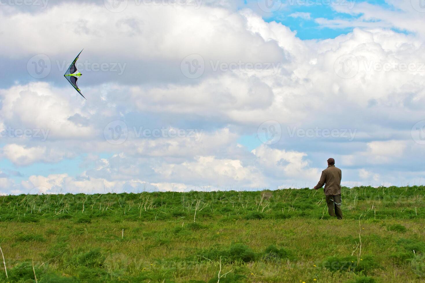 A Man flying his kite at the steppe photo