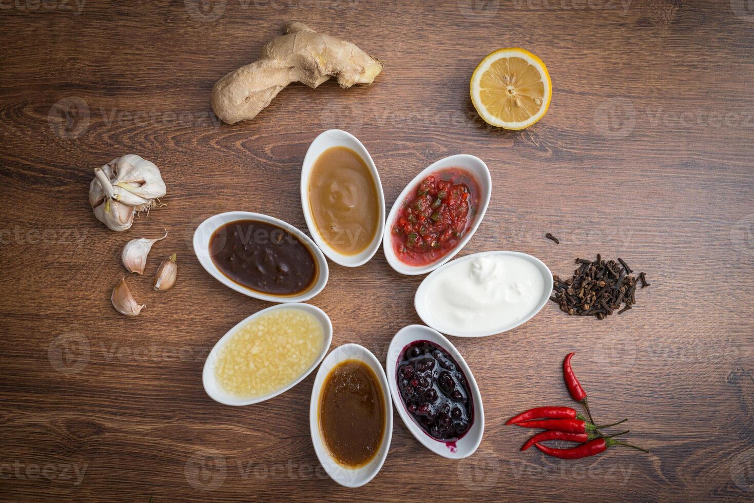Sauces and spices. A set of popular sauces and spices on a wooden background. photo