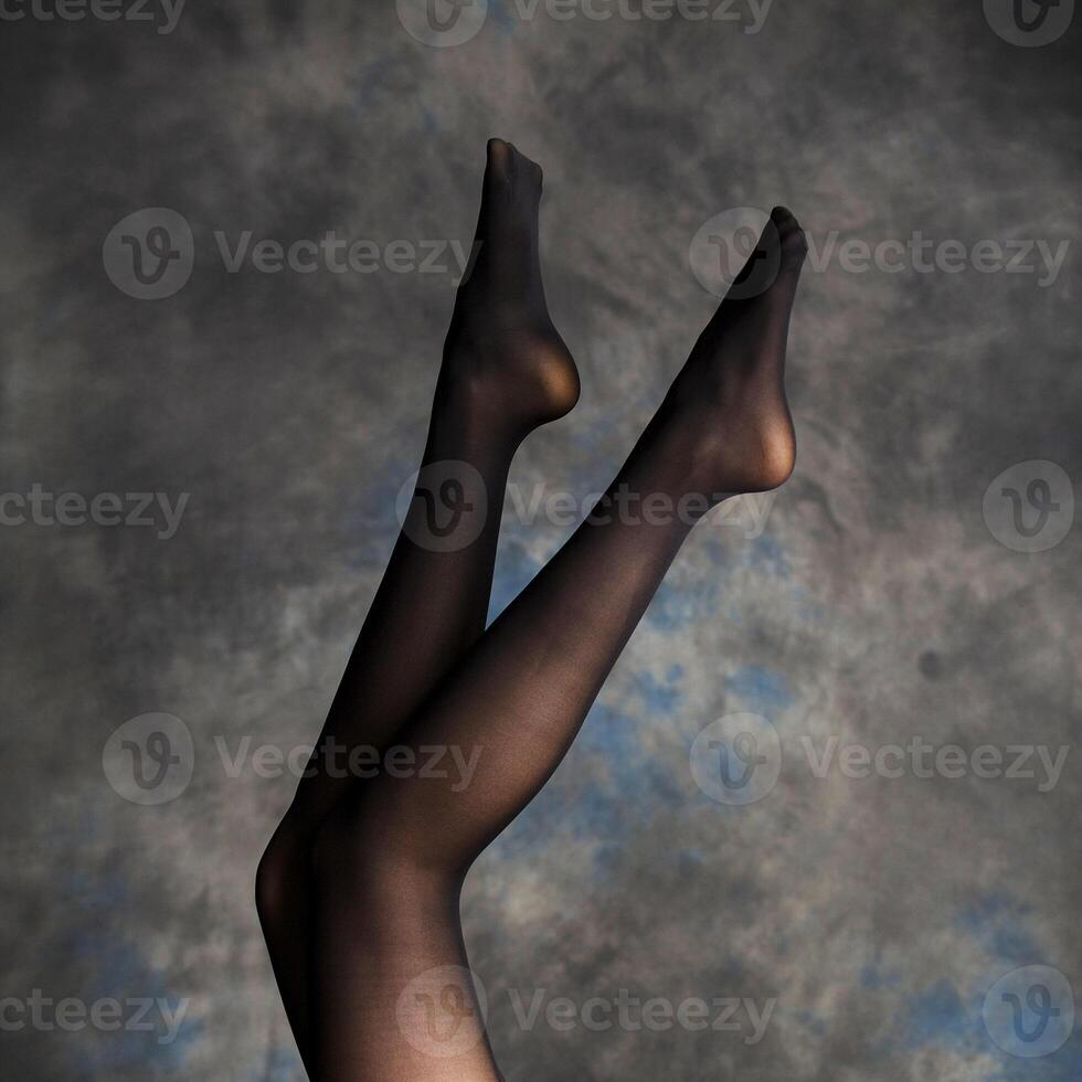 Beautiful woman legs on dark background photo