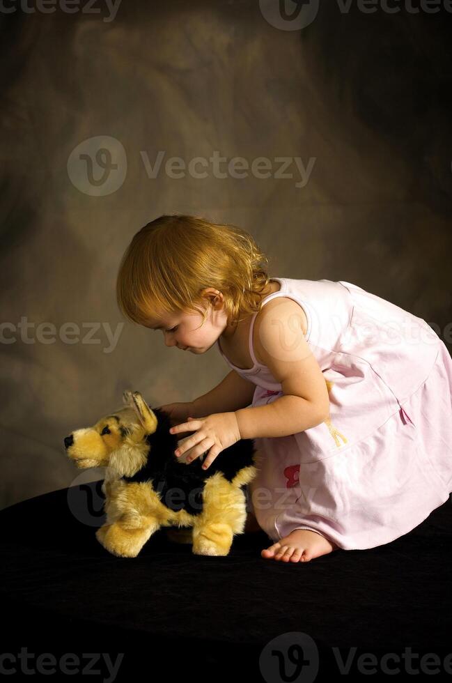 Girl plays with the toy dog photo