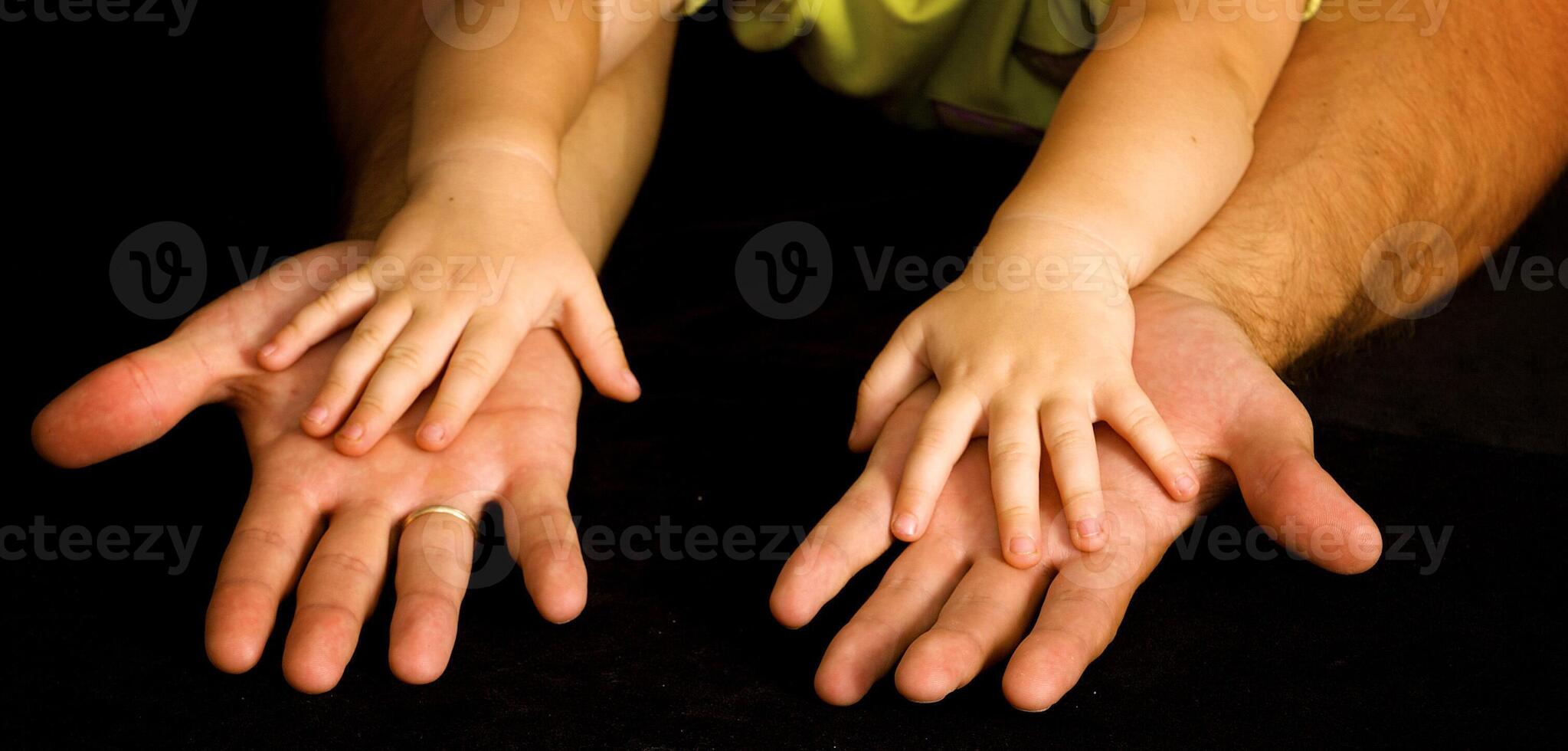 Daughter holds the hand of the father photo