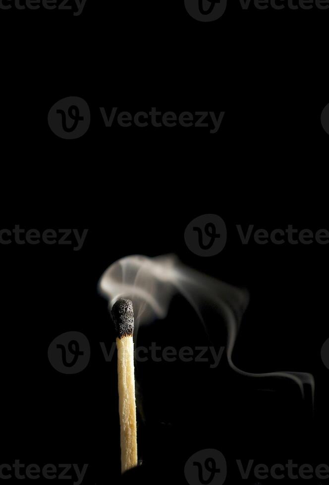Wooden match burning on a black background photo