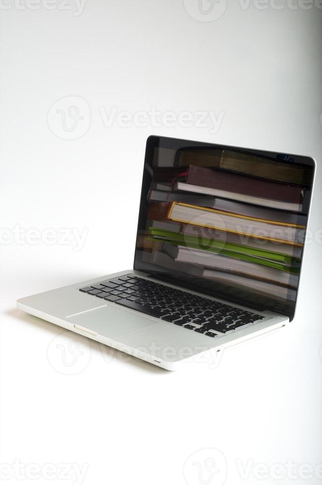 Stack of book and laptop photo
