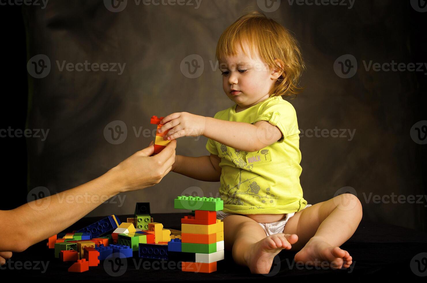 Small girl plays with the designer photo