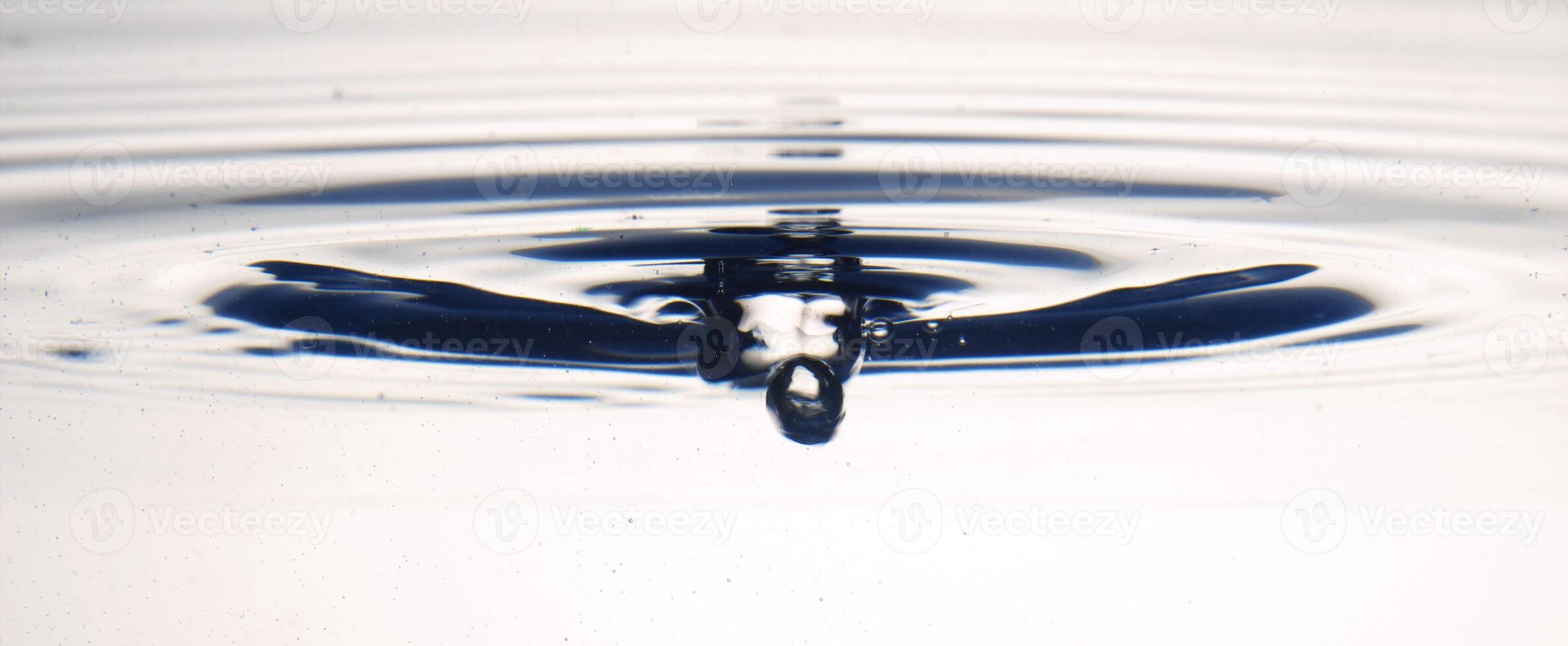 The round transparent drop of water, falls downwards photo
