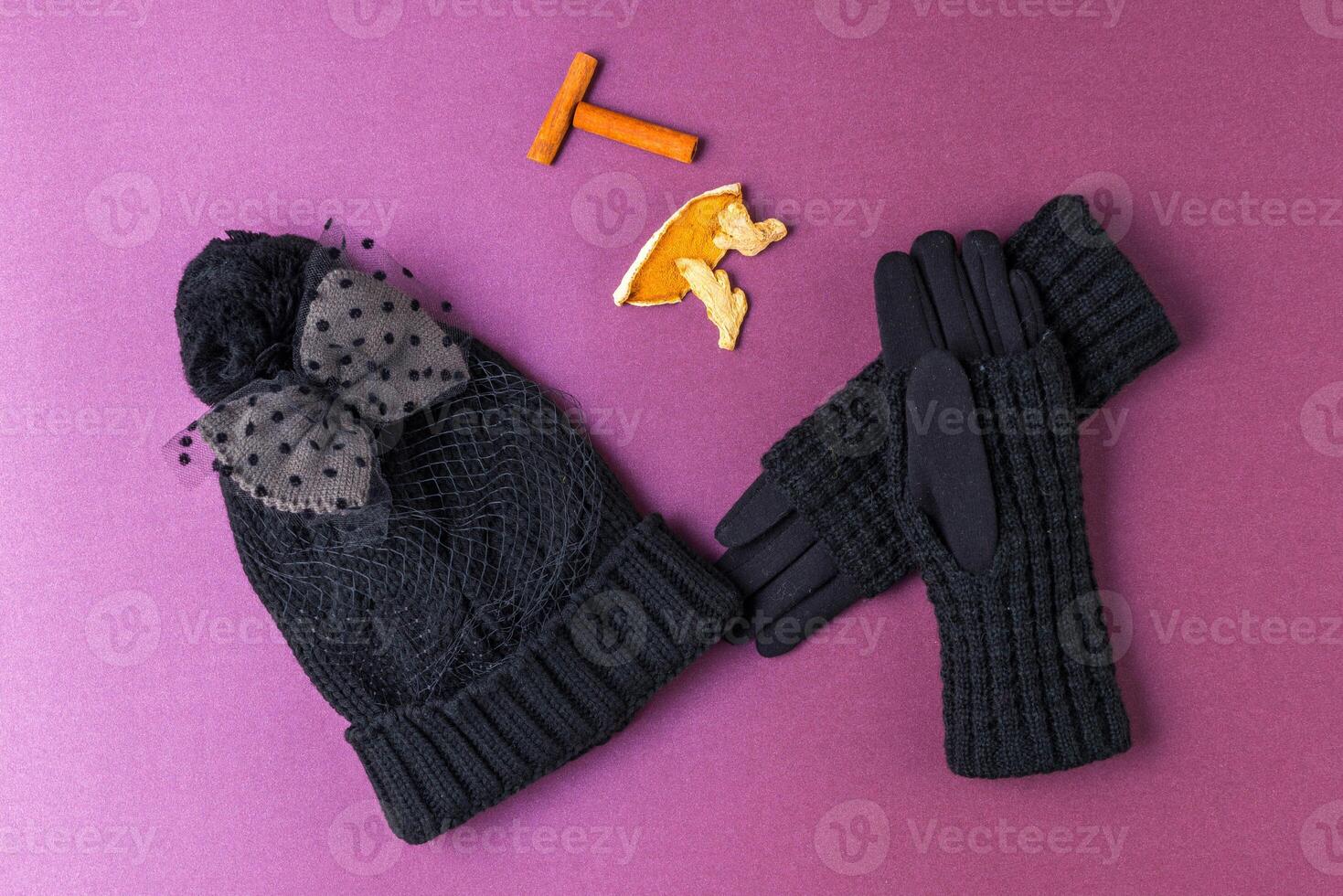 Set of winter cap, scarf and gloves on colored background photo