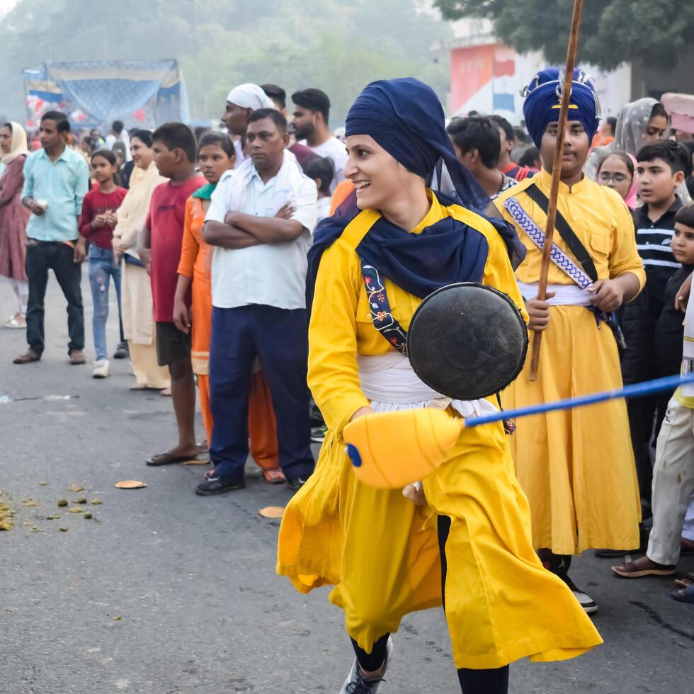 Delhi, India, October 2, 2023 - Sikhs display gatka and martial arts during annual Nagar Kirtan, Traditional, procession on account of birthday of Guru Nanak Dev ji, Nagar Kirtan in East Delhi area photo