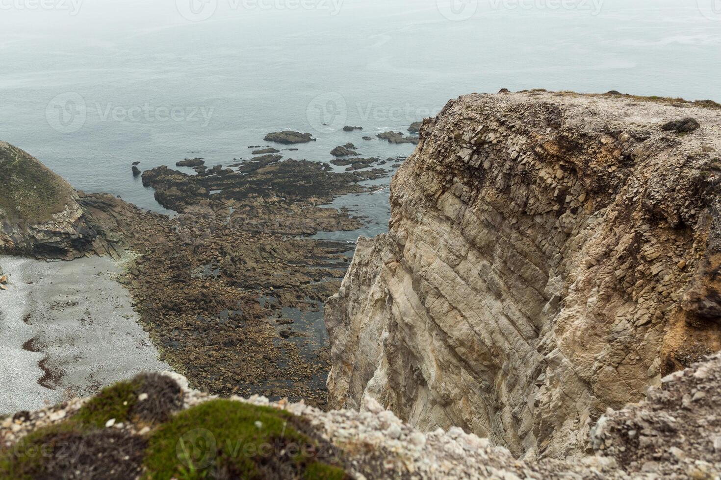 Summer Atlantic rocky coast view Big stony rockfall on precipice shore and ocean surf waves. Crozon, France View near the Memorial naval aviation Cape of the Goat May 2018 photo