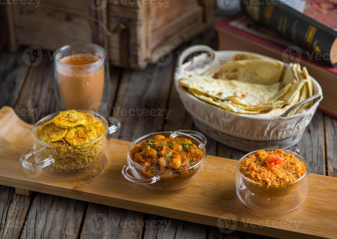 Assorted break fast set balalet or balaleet, aloo nakhi,aloo karahi, tomato egg with bread and coffee served in a dish isolated on cutting board side view of breakfast on wooden background photo