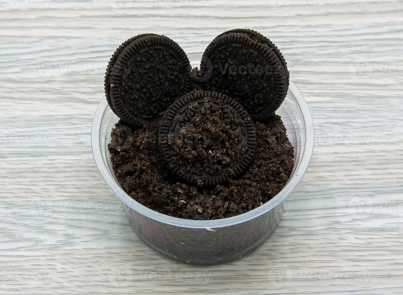 Oreo cookies with powder served in disposable cup side view of indian and pakistani dessert photo