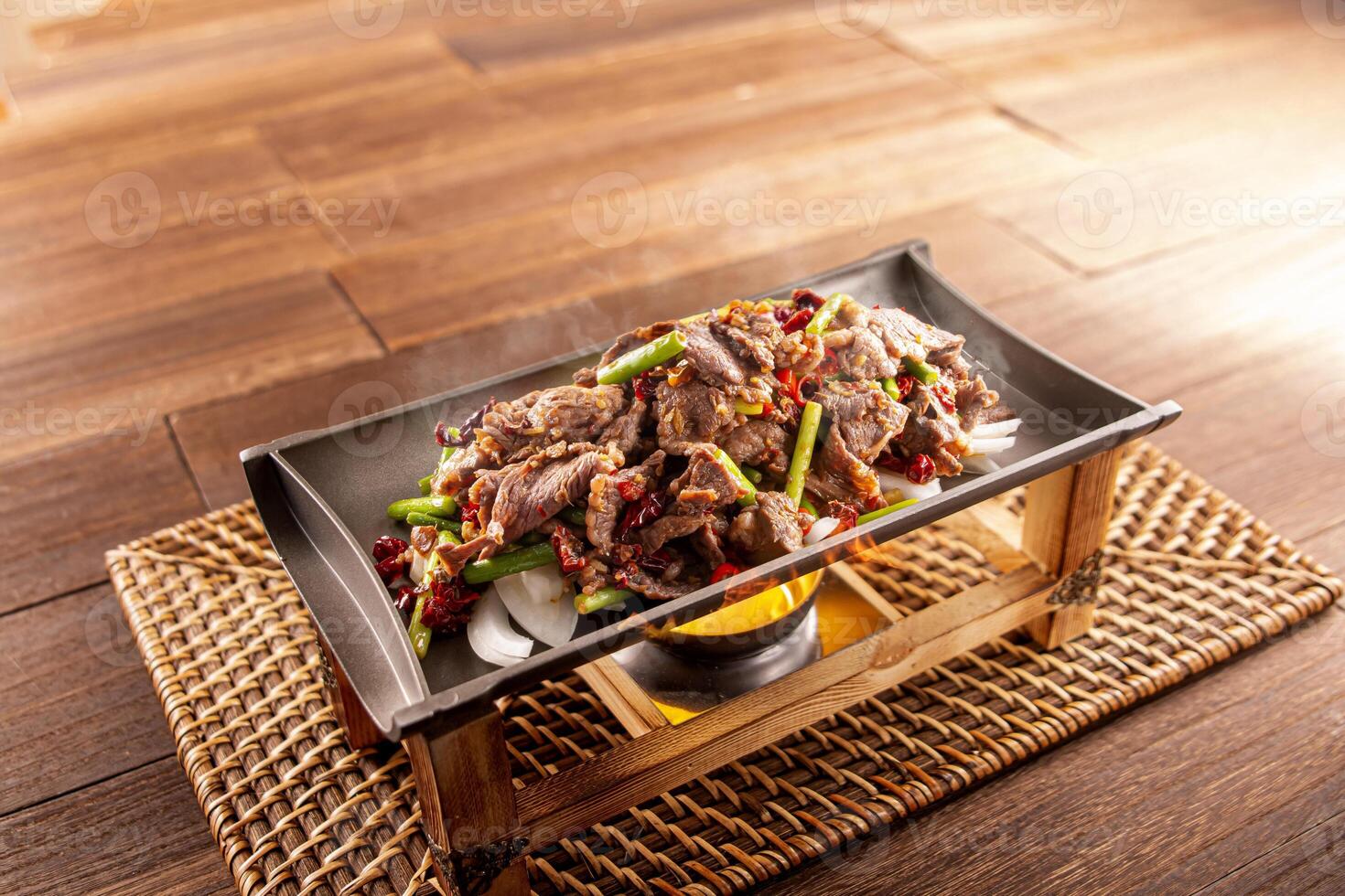 Spicy chilli Hunan Sizzling Beef served dish isolated on wooden table top view of Hong Kong food photo