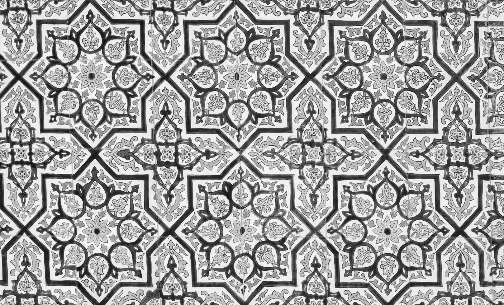 Black and white geometric traditional Islamic ornament on a tile. Fragment of a ceramic mosaic.Abstract background. photo