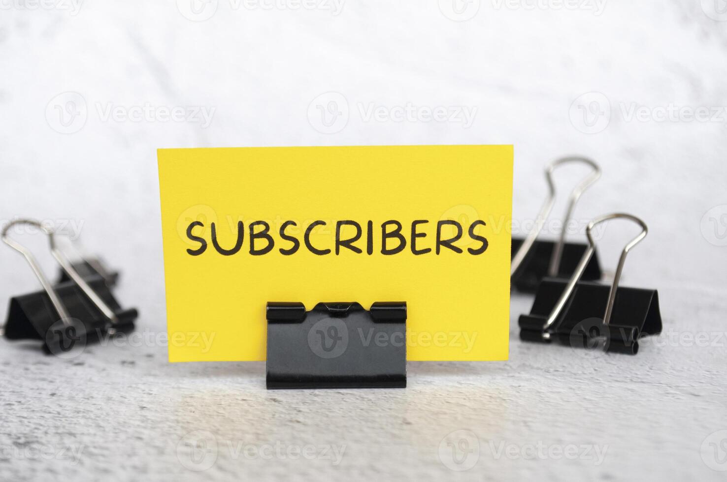 Subscribers text on standing yellow paper. Lead generation concept. photo