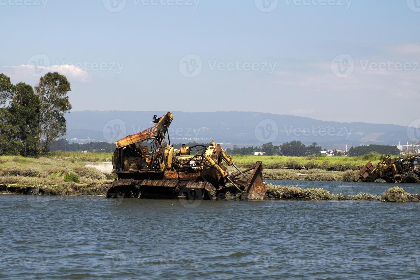 abandoned rusted bulldozer in Aveiro lagoon Ria de Aveiro located on the Atlantic coast of Portugal photo