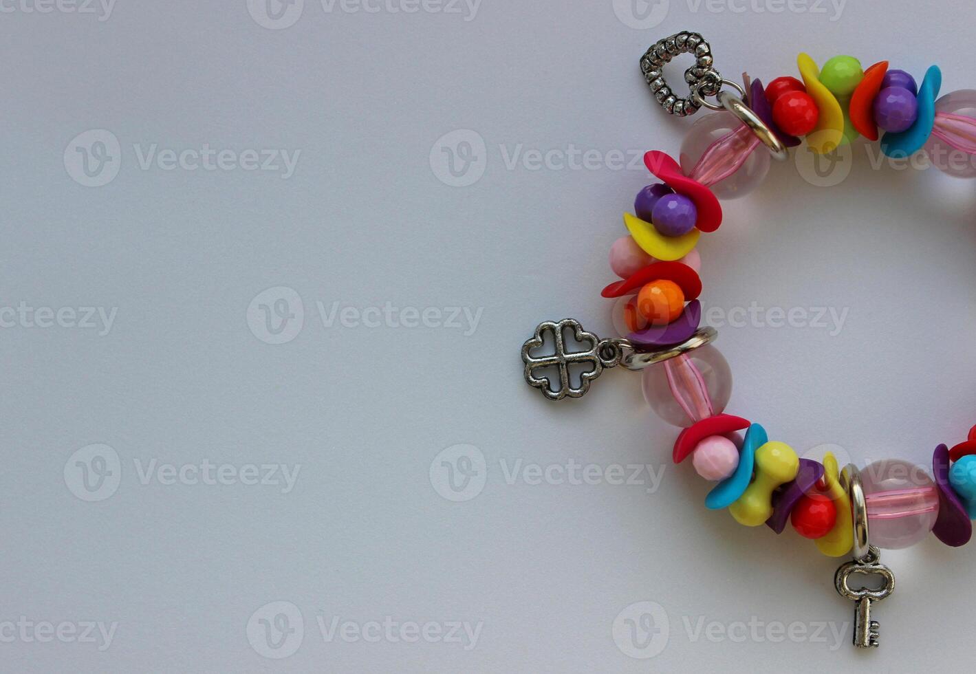 Concept For Postcard Of Wallpaper With Colorful Beads And Silver Charms Bracelet In A Side Of Image photo
