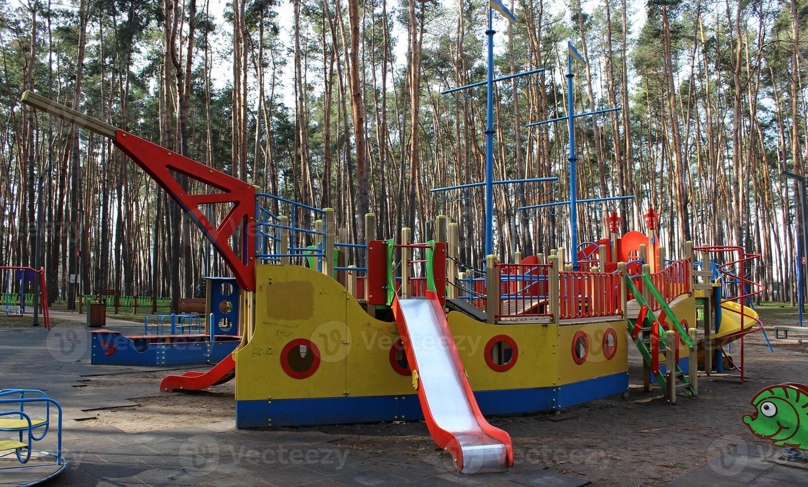 Outdoor game complex with children's slides in the form of a ship with masts in the recreational area photo