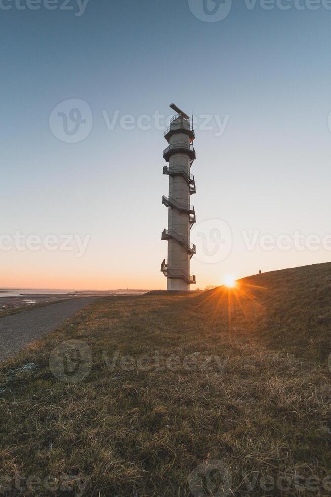 Radar Ossenisse under the sunrise rays in the south of the Netherlands. Security tower for the protection of the Holland photo
