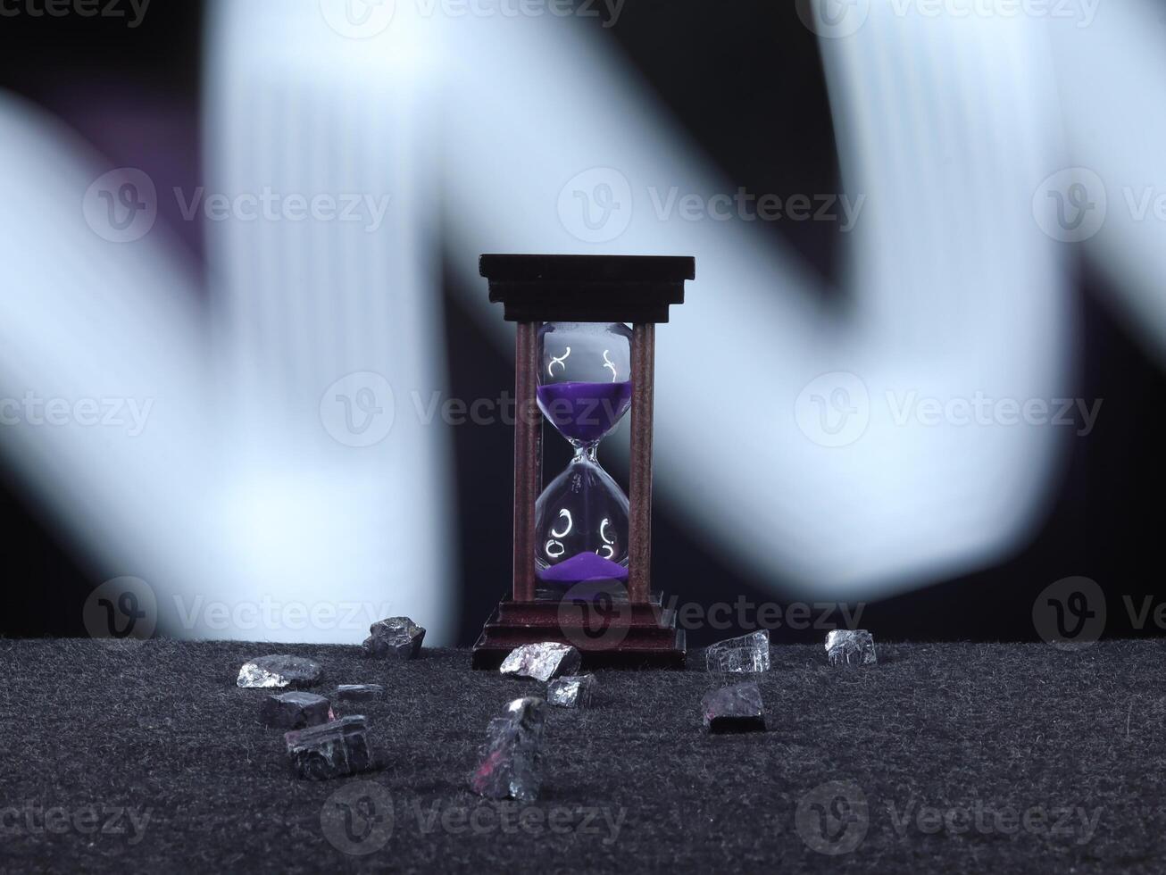 An Hourglass with Vibrant Purple Sand Measuring Time Elegantly photo