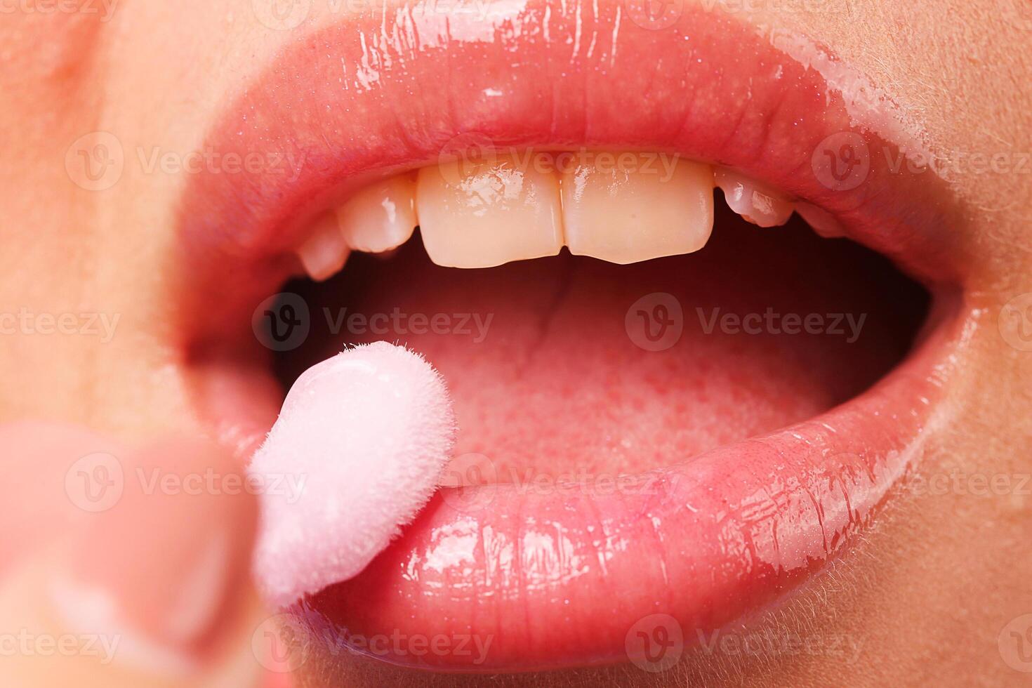 Close up of pink lips with lip gloss photo