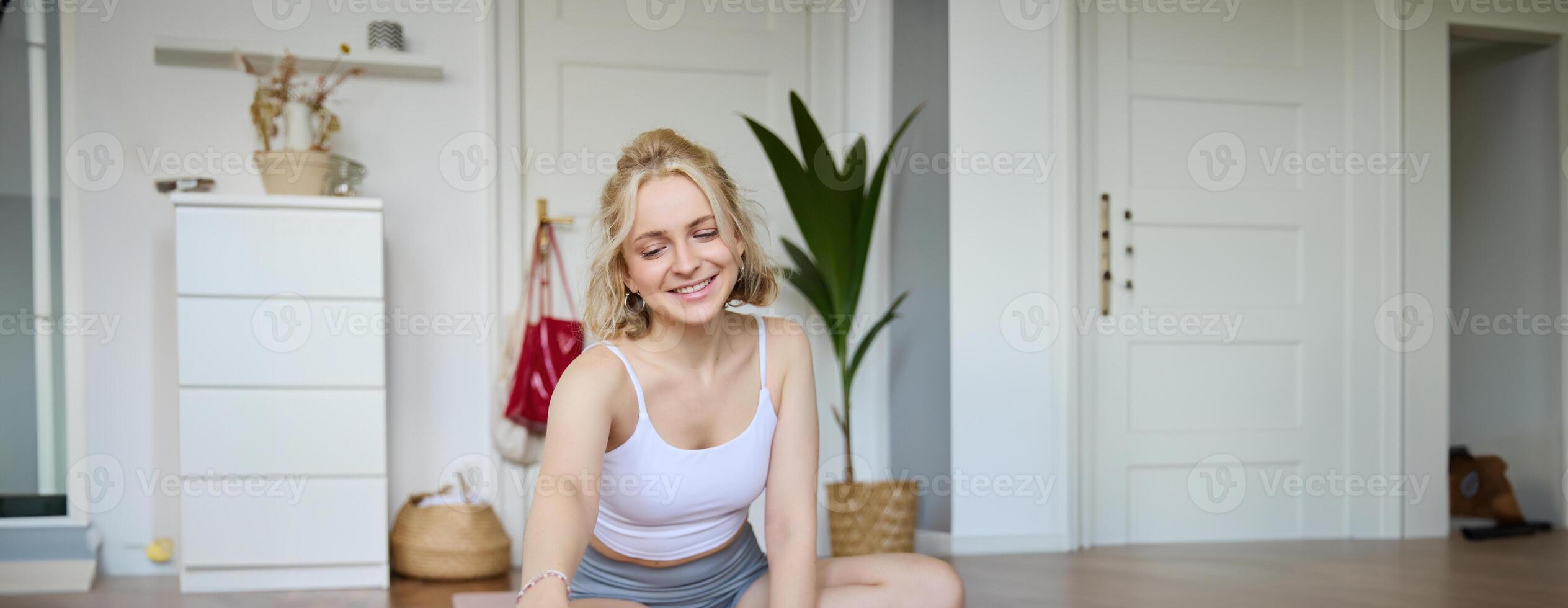 Vertical shot of athletic, fitness woman recording of herself on digital camera, creating content for social media about workout and home exercises photo