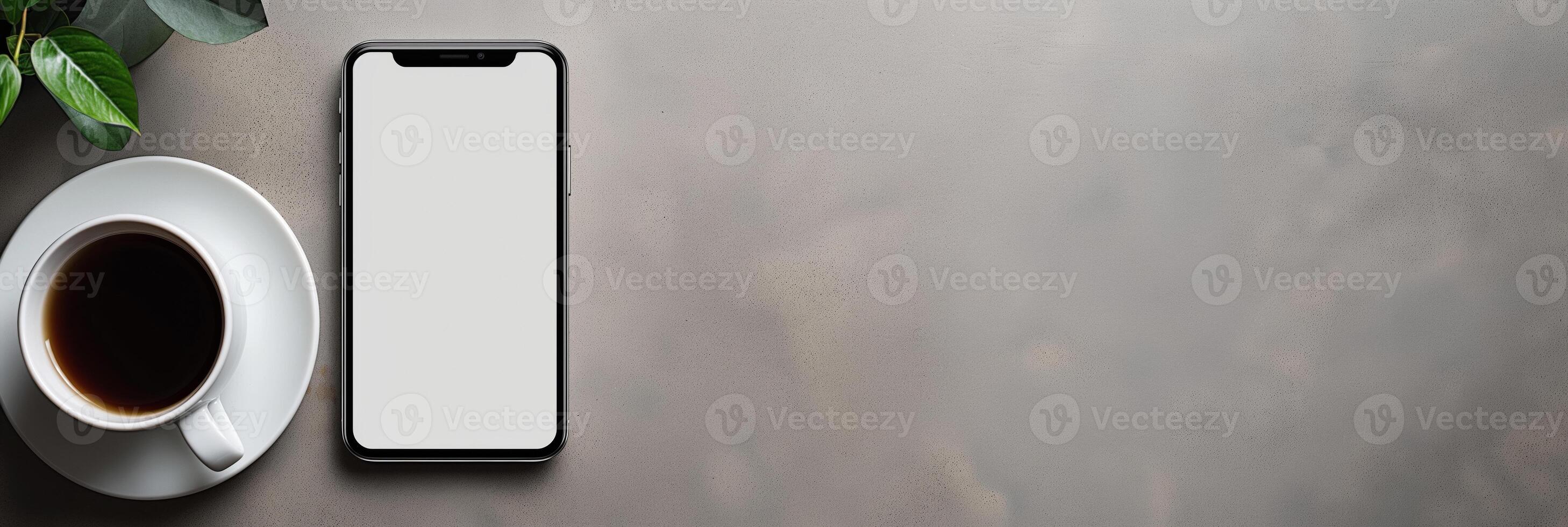 A portable communications device, a smartphone, and a plant on wood table. Mockup. Copy Space. photo