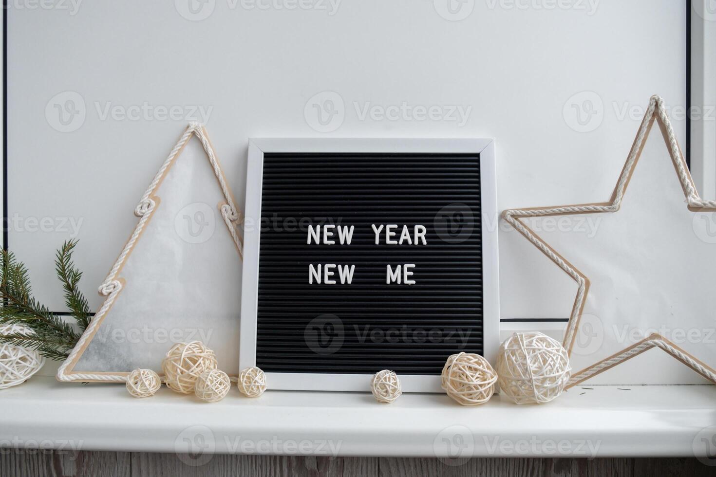NEW YEAR NEW ME text on black letter board with cozy minimalistic handmade Christmas decor. New year aims resolutions. Low key festive Planning and setting goals concept photo