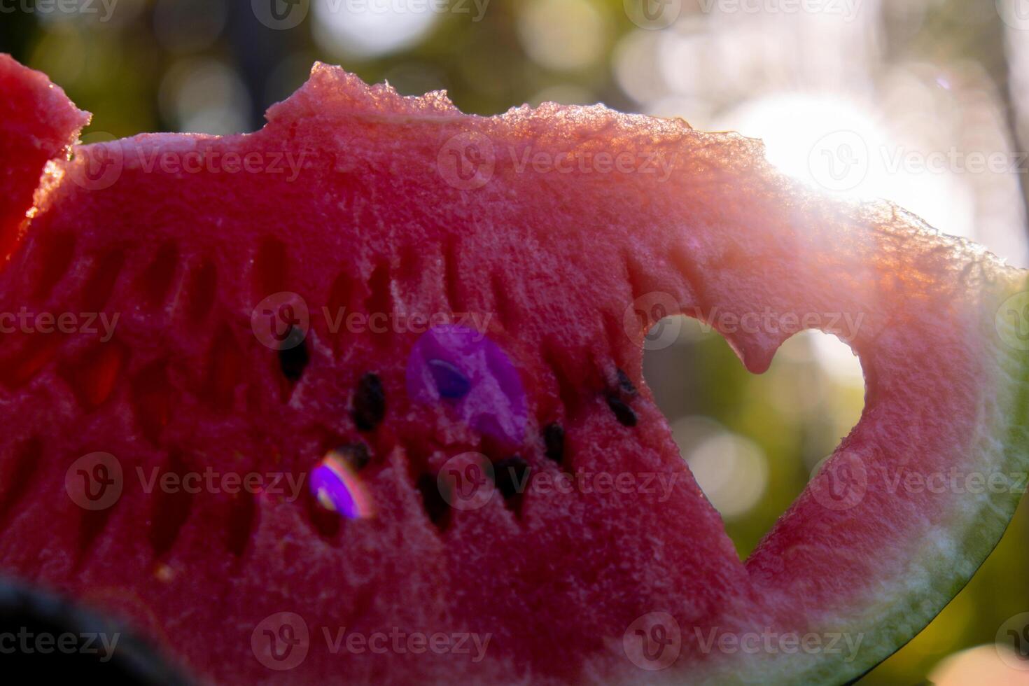 Summer seasonal food. Juicy red watermelon slice cut in heart shape outdoors summertime holidays sunbeams. Concept of enjoying the moment in fresh air. Sustainable calm lifestyle pastoral life cottagecore escapism photo
