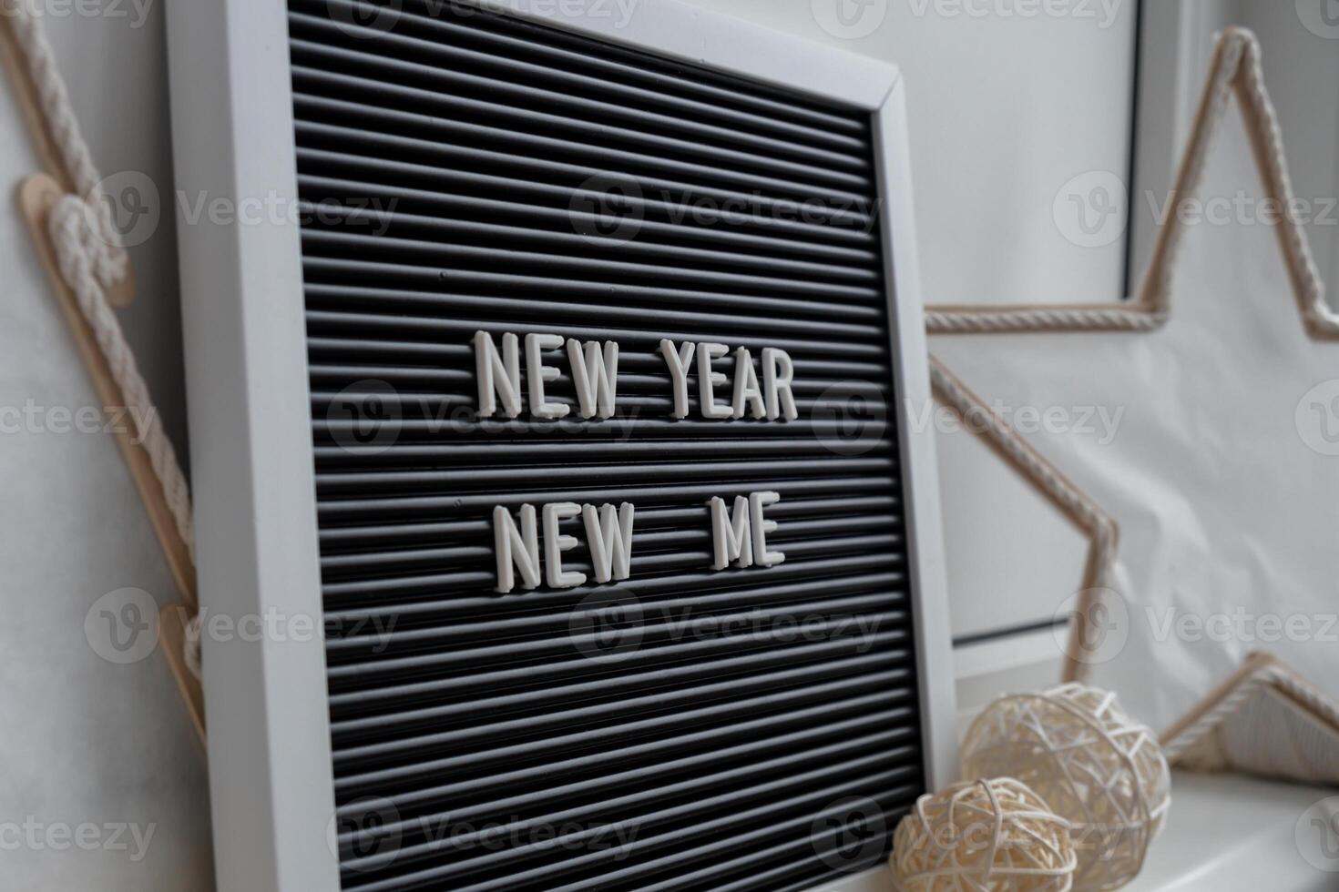 NEW YEAR NEW ME text on black letter board with cozy minimalistic handmade Christmas decor. New year aims resolutions. Low key festive Planning and setting goals concept photo