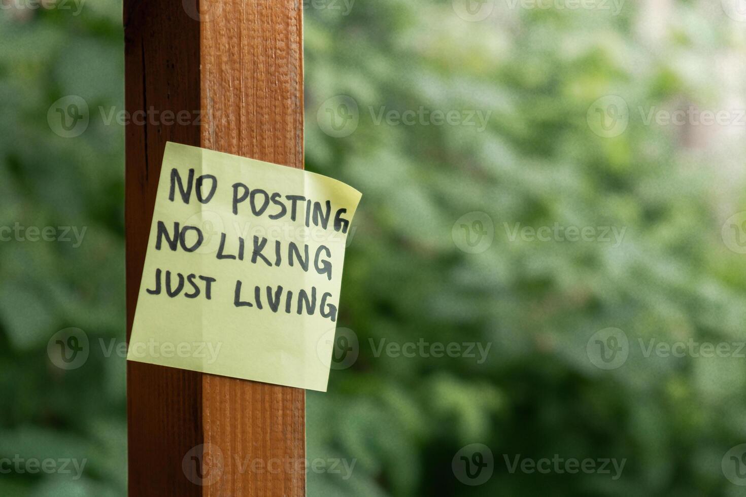 NO POSTING NO LIKING JUST LIVING text on paper note on background of greenery garden. Concept of social media technology detox. Farmcore nature core sustainable slow life photo