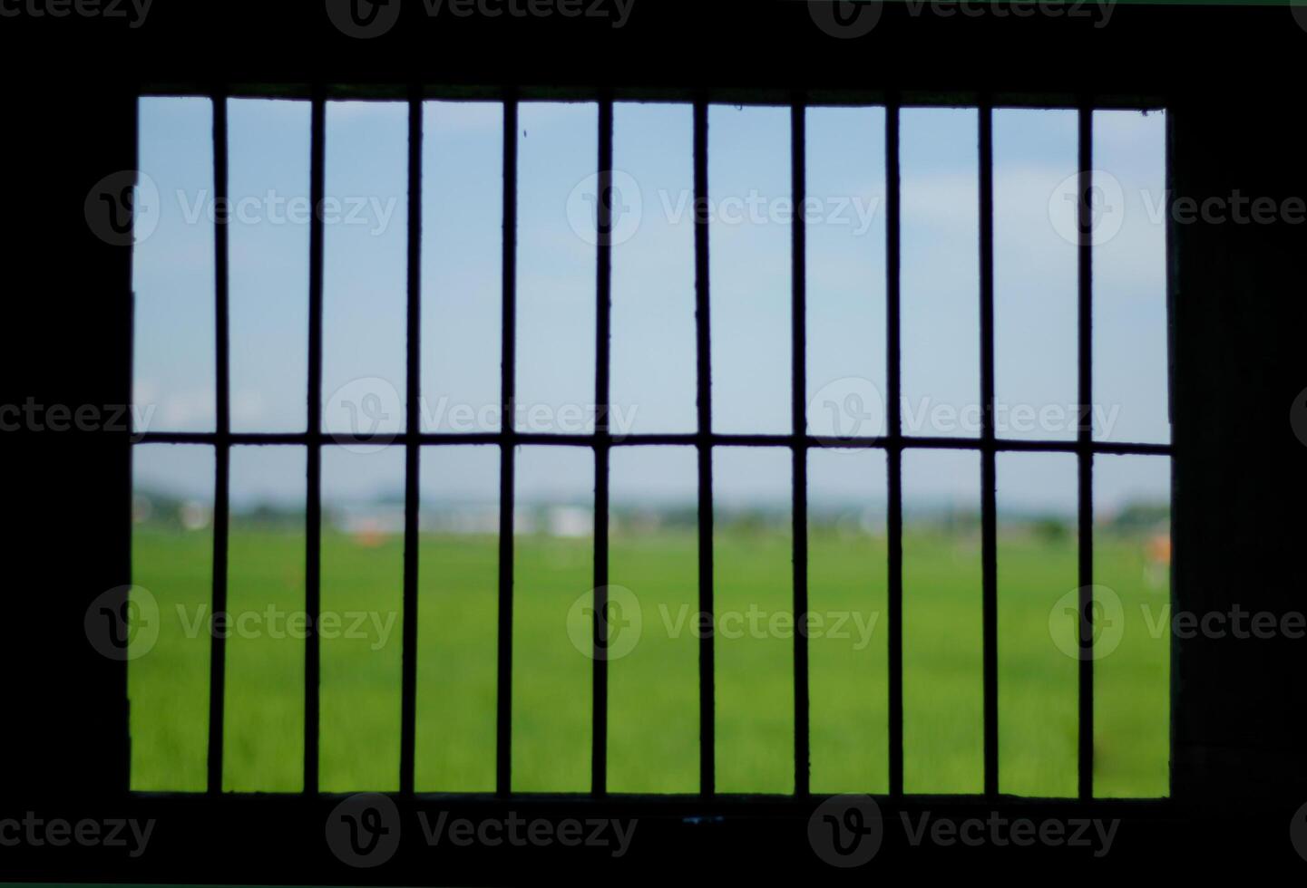 The prisons iron bars with a refreshing view beyond photo