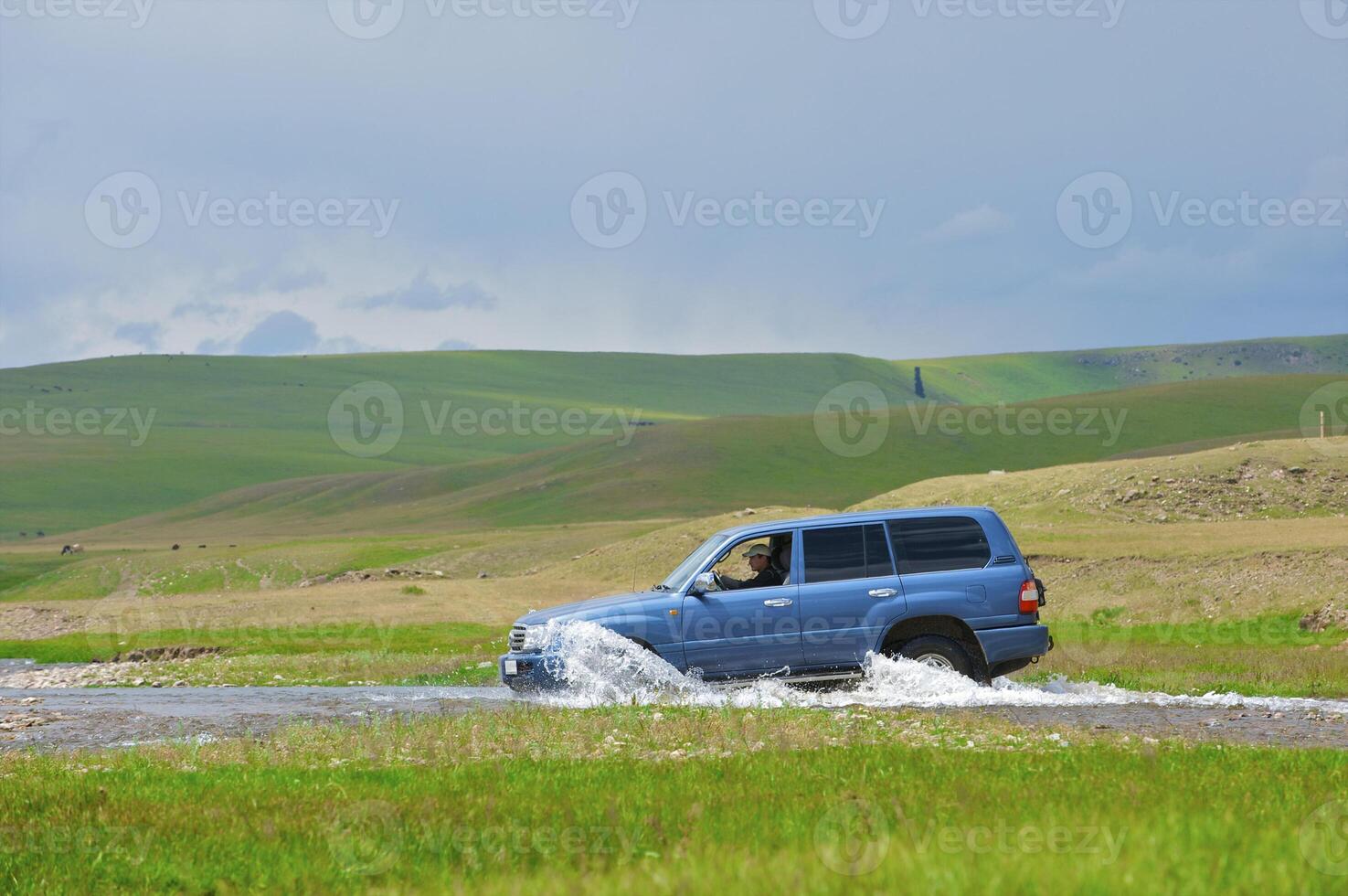 Off-road car crossing the river in mountains photo