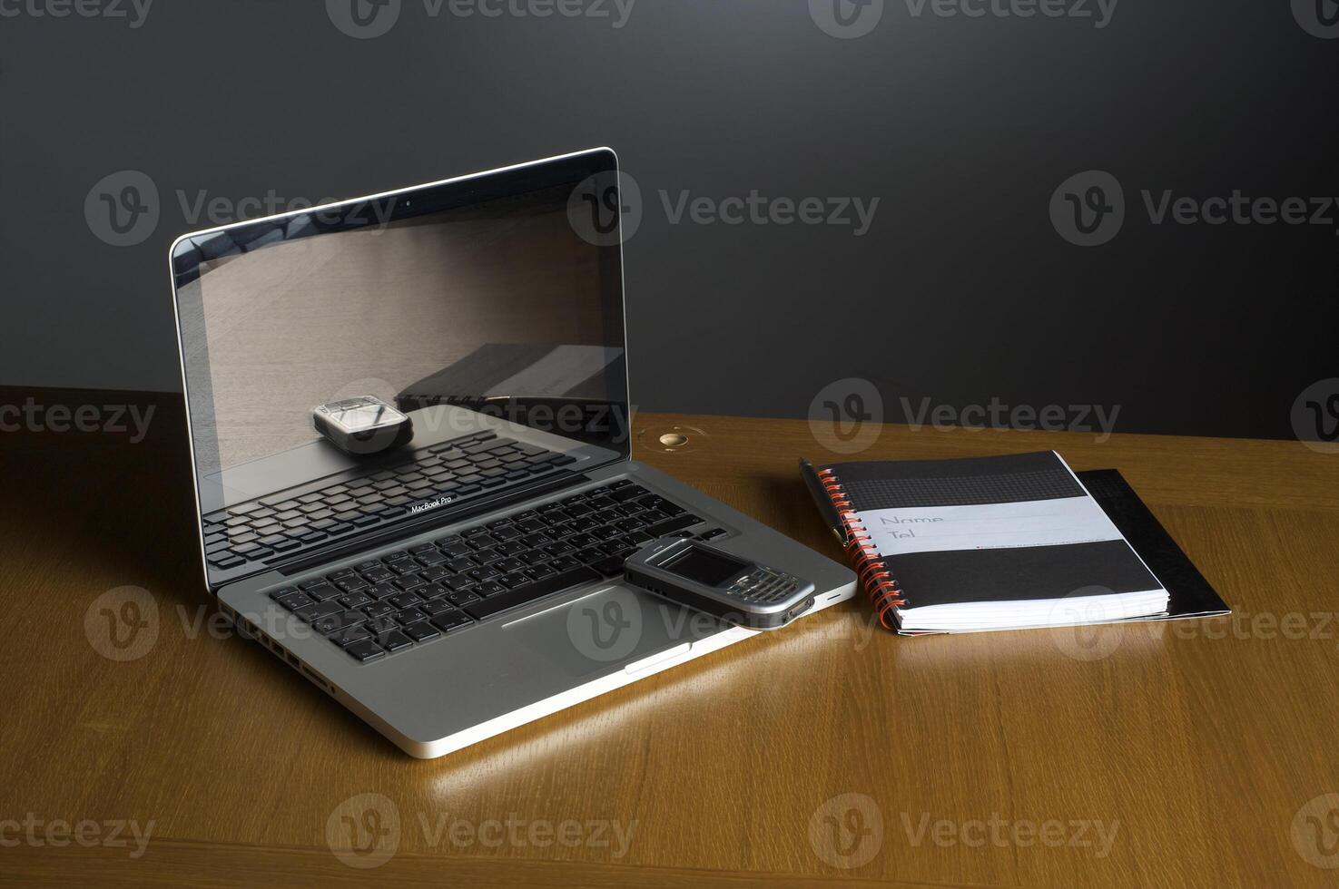 Phone, laptop and empty notebook on the desk photo