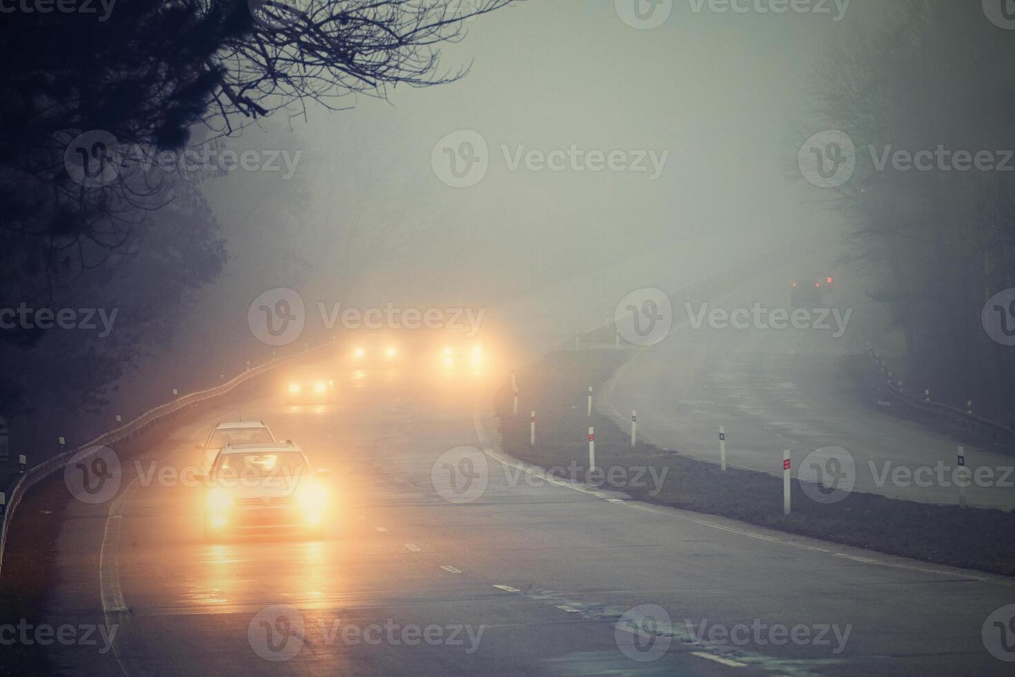 Cars in the fog. Bad winter weather and dangerous automobile traffic on the road. Light vehicles in fog. photo