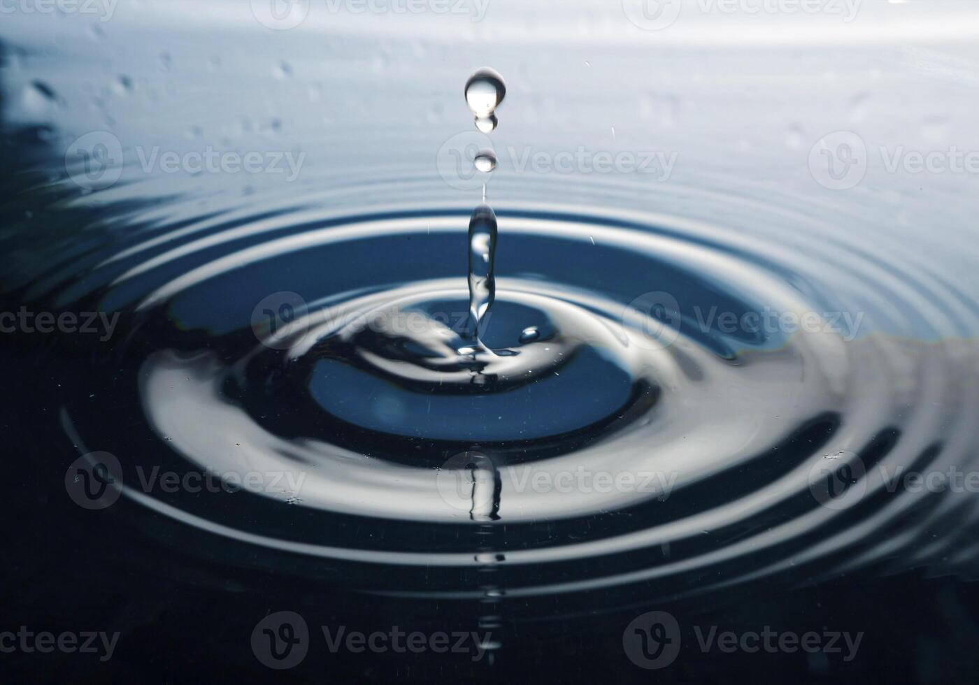 The round transparent drop of water, falls downwards photo