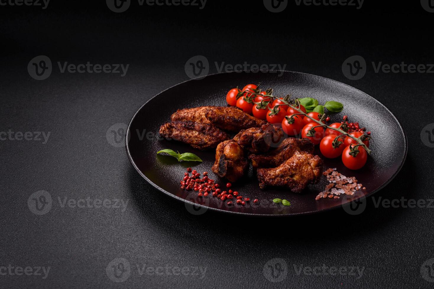 Delicious juicy chicken wings baked on the grill with salt, spices and herbs photo