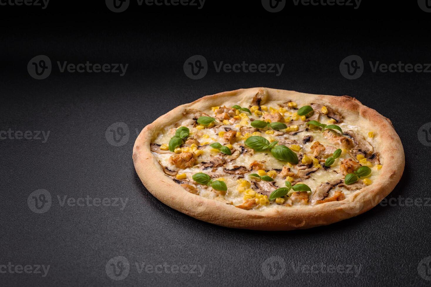 Delicious pizza with corn, cheese, tomatoes and mushrooms, salt, spices and herbs photo