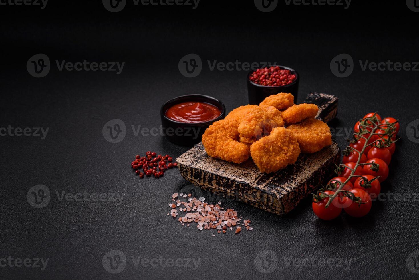 Delicious fresh crispy chicken nuggets on a dark concrete background photo