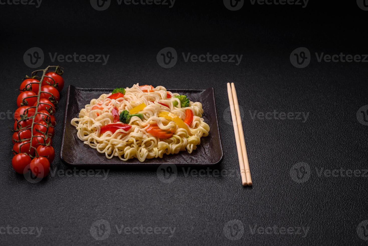 Delicious Asian dish rice noodles or udon with vegetables, spices and herbs photo