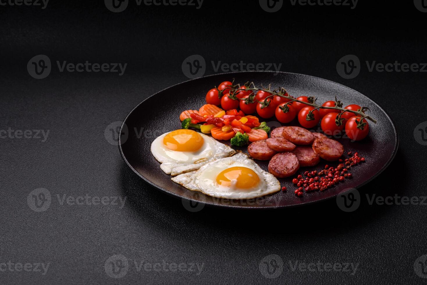 Delicious nutritious breakfast with fried eggs, sausage, steamed vegetables photo